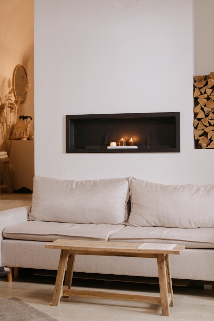 Warm and inviting Scandinavian living room with cozy couch, wooden table, and burning candles.